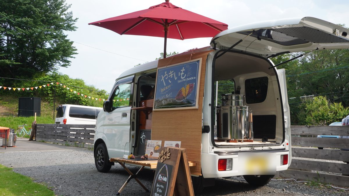 日除けと折りたたみ机を出した、軽バンでの小さな出店の全景
