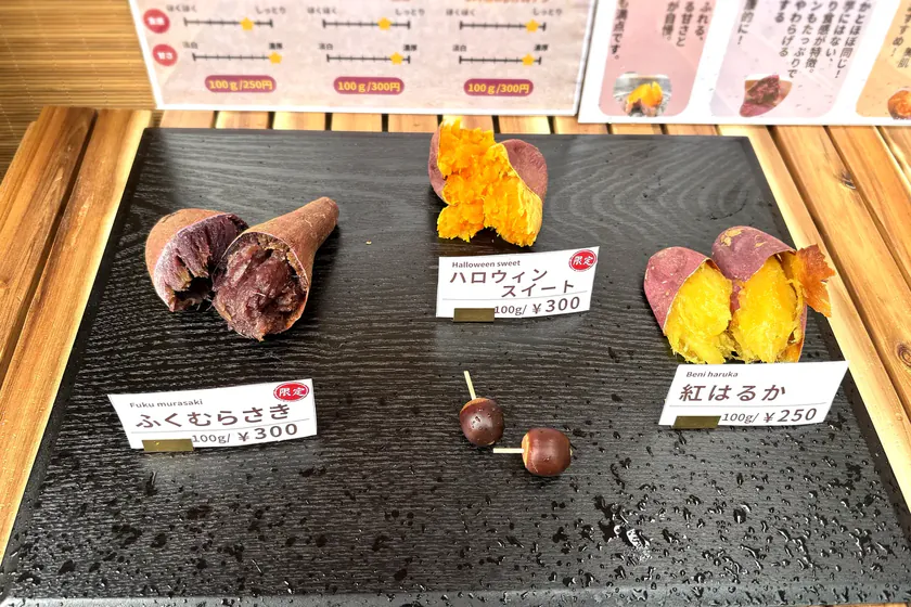 黒いスレートに並んだ、ふくむらさき・ハロウィンスイート・紅はるかの3品種の焼き芋と品種案内
