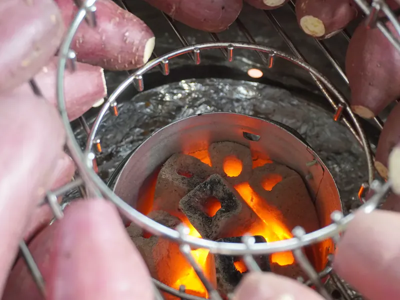 焼き芋機の中央で赤く熾きた炭火を囲む燕三条製の焼き網と、周りに並んだ紅はるか